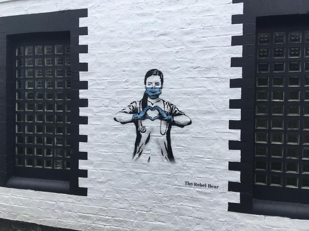 Wall art showing an NHS worker with a face mask making a heart with her hands