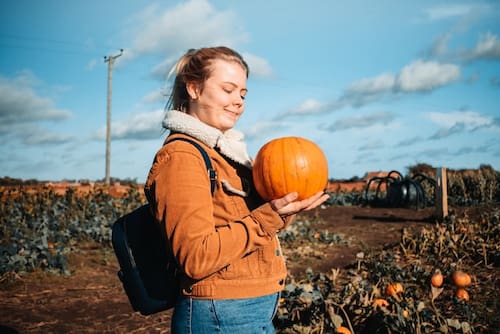 A women holding a mini pumpkin