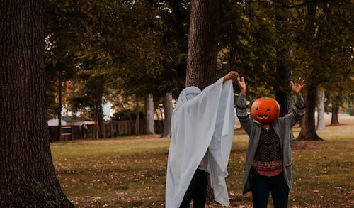 Two friends dancing in the woods wearing Halloween costumes