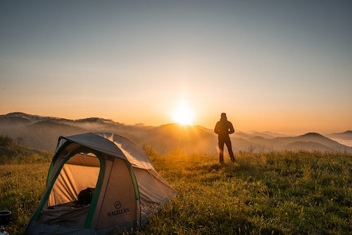 A man camping watching the sunrise
