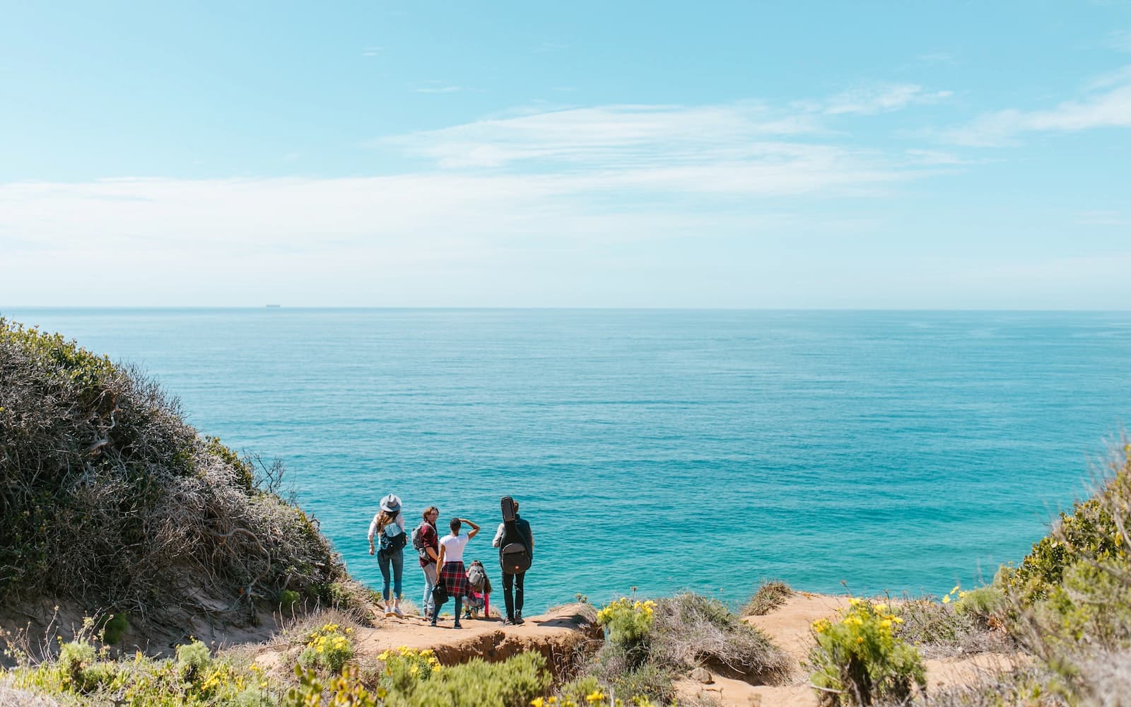 A group of friends near the ocean on a sunny day.