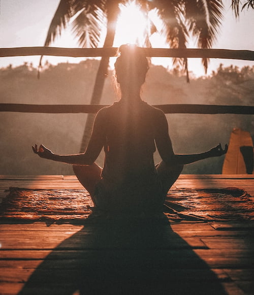 A woman doing yoga in the sunset