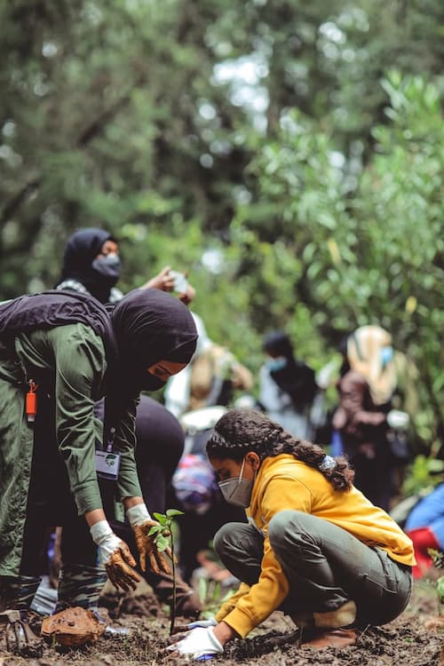 A woman and child planting native trees in Ethiopia
