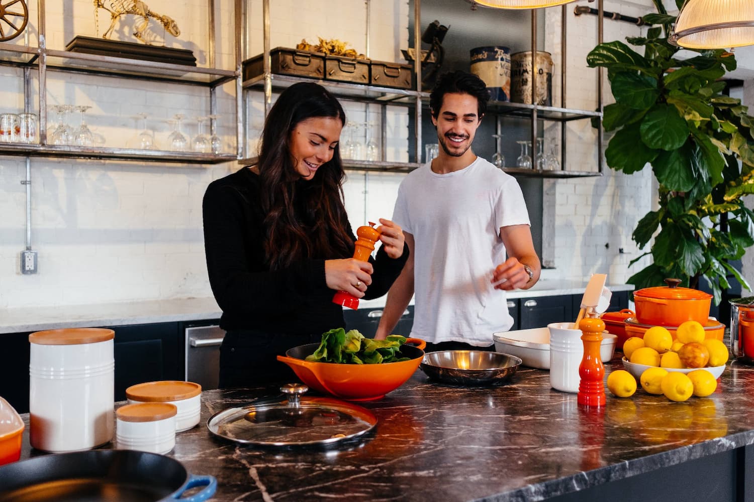 2 people smiling in a kitchen full of Le Creuset