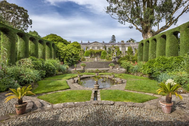 The gardens of a National Trust property, with a grand house in the background
