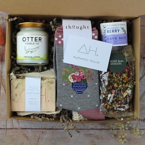 eco box filled with sustainable and ethical products, such as candles, soaps, and socks