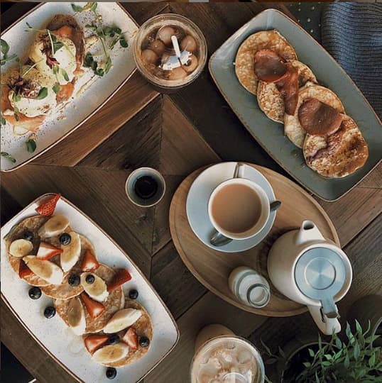 Top-down shot of an afternoon tea set up with pancakes and strawberries