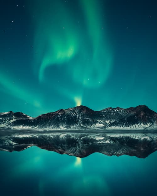 Aurora borealis blue curtain over volcanoes of Iceland