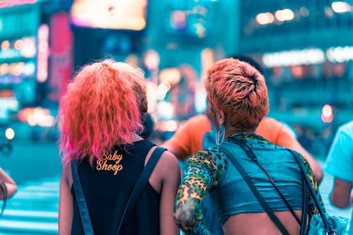 Friends crossing neon-lit Shibuya crossing in Tokyo, Japan
