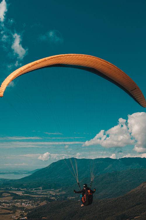A man paragliding across the mountains