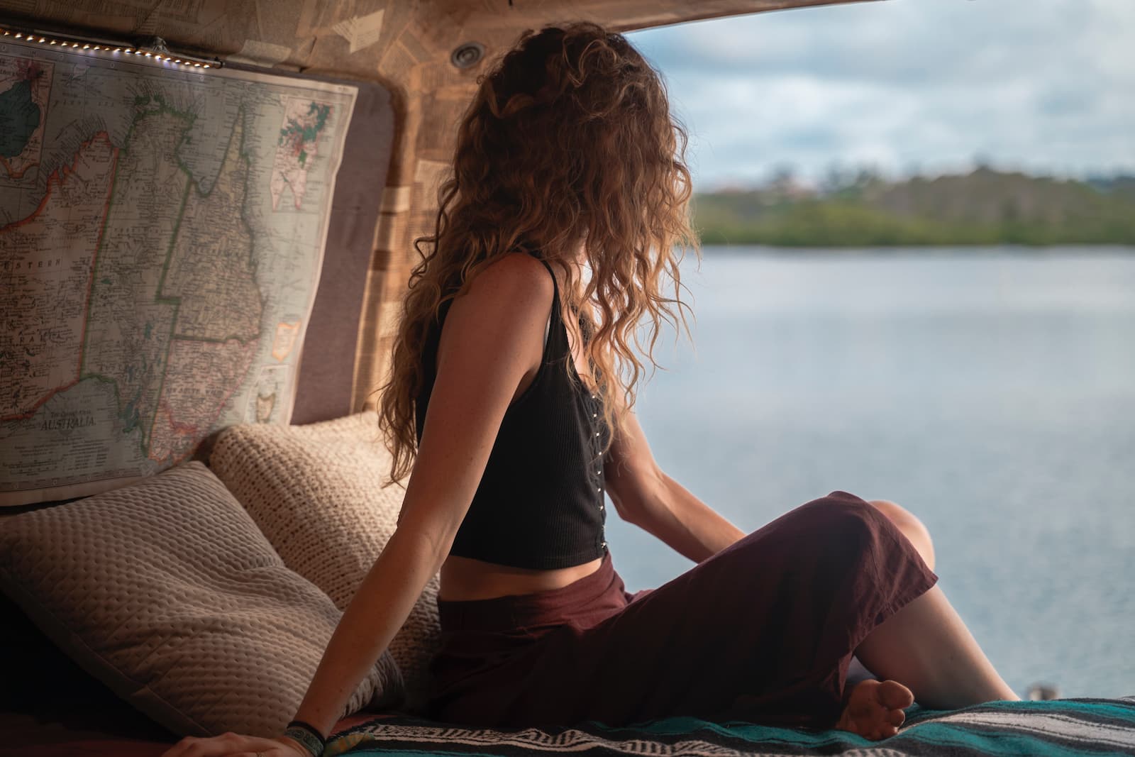girl overlooking a lake from her van