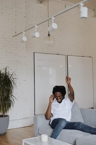 man on sofa calling excitedly