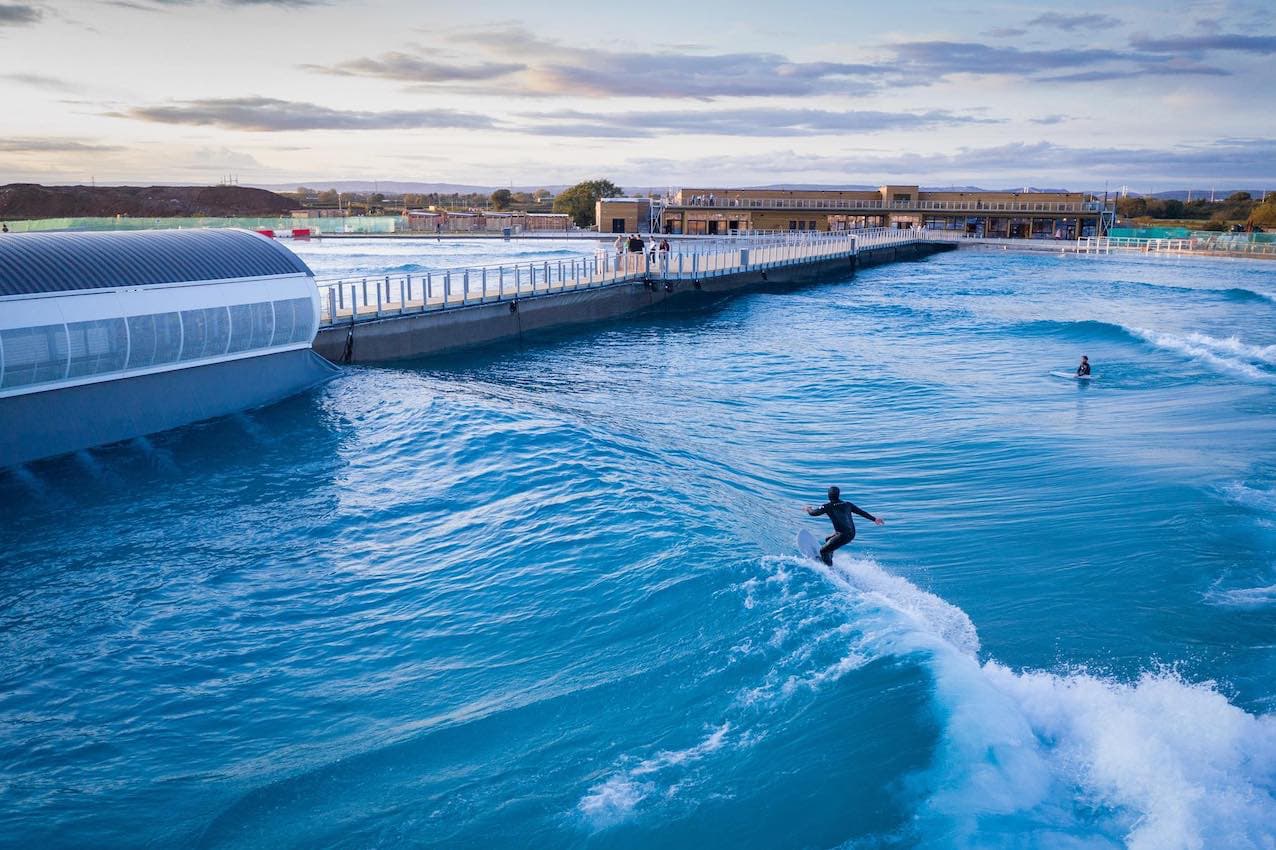 man surfing blue artificial wave created at The Wave in Bristol