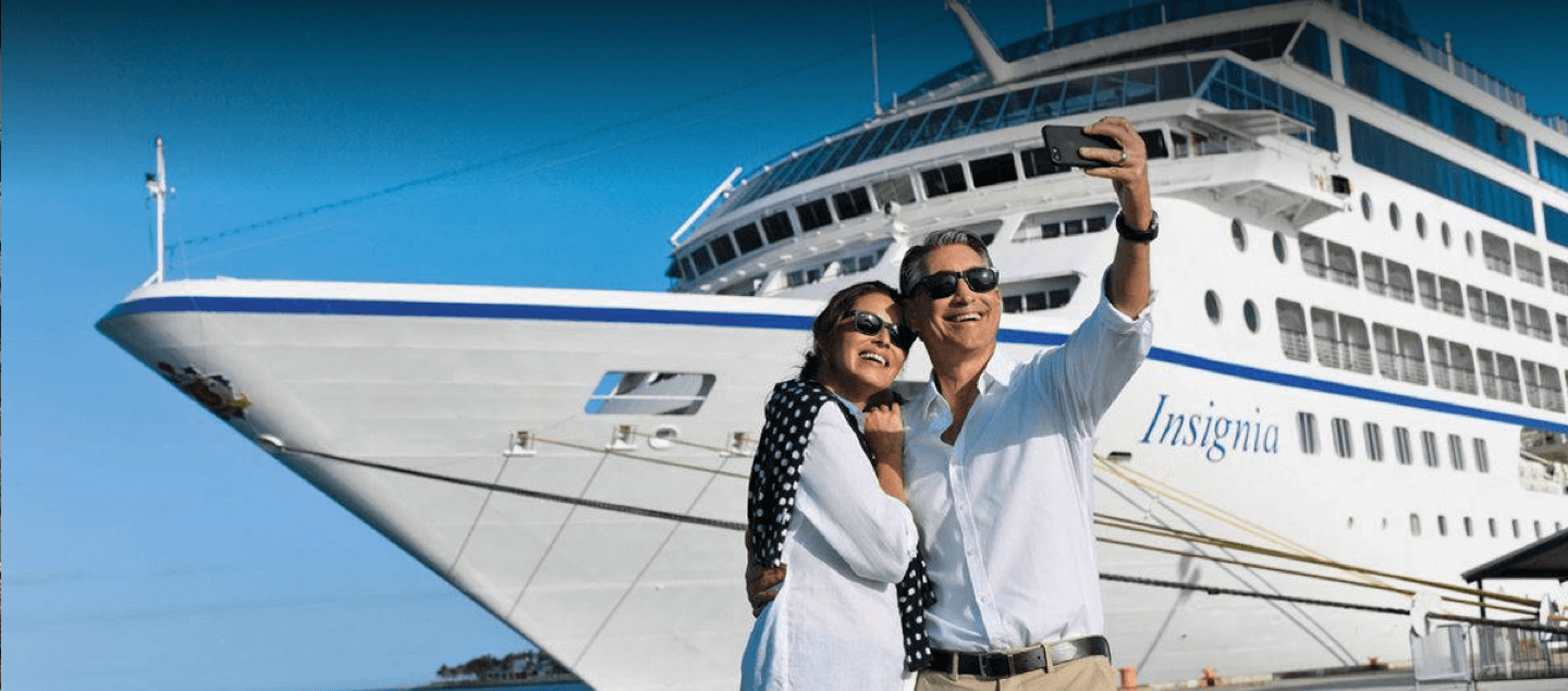 Couple taking selfie in-front of large cruise ship