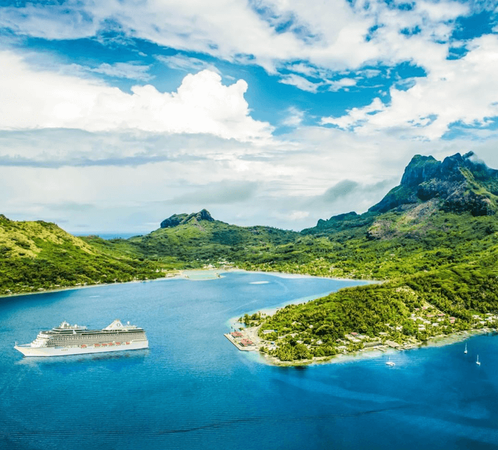 cruise ship anchored in small bay with pristine, unspoilt beaches