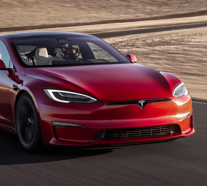 red Tesla model S racing round track in desert